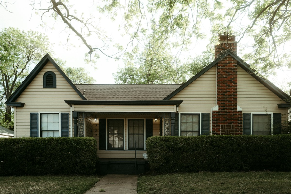 A residential home with a wide roofline and landscaped yard